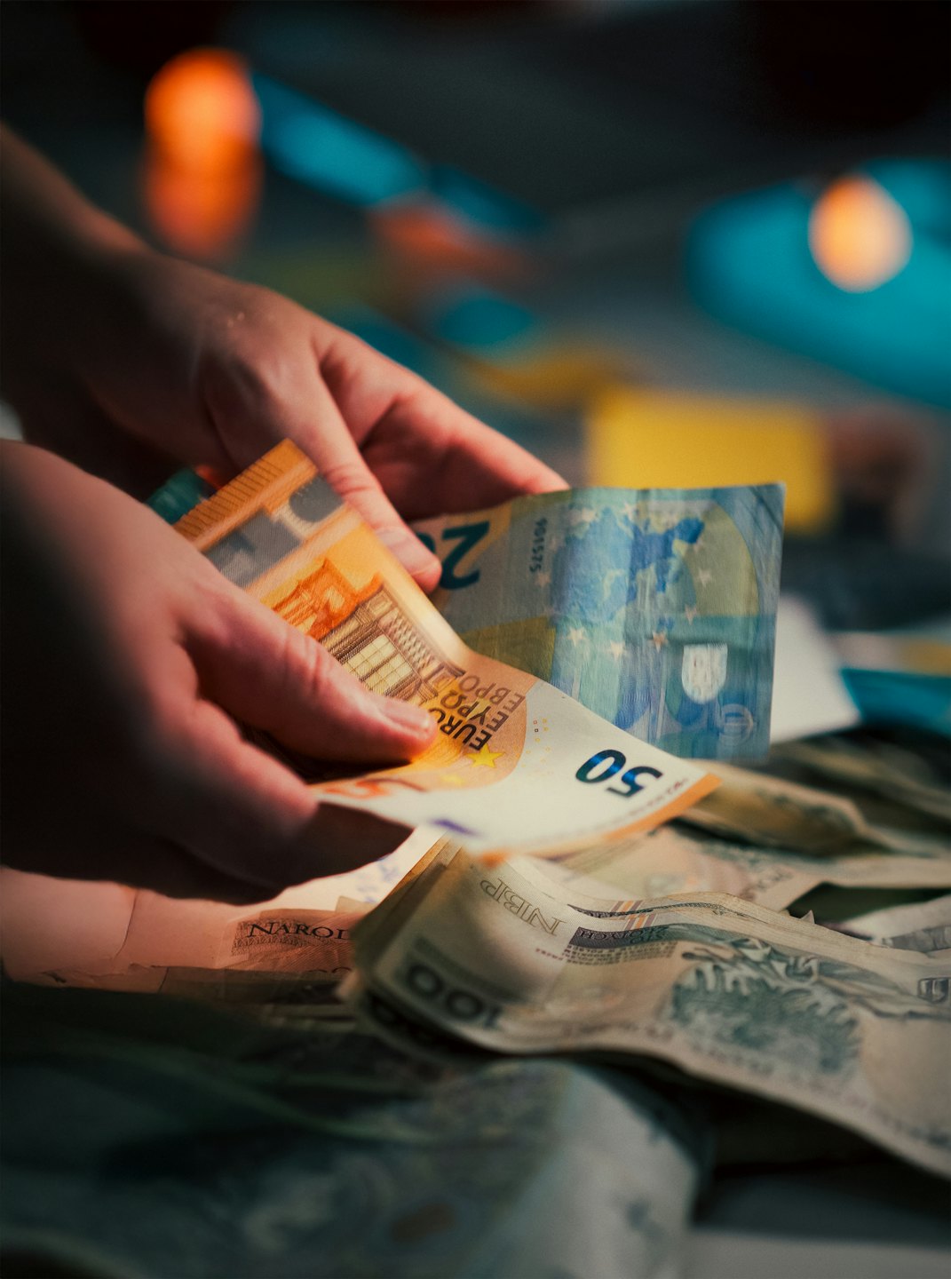 Due mani che ordinano varie banconote in euro su un tavolo.